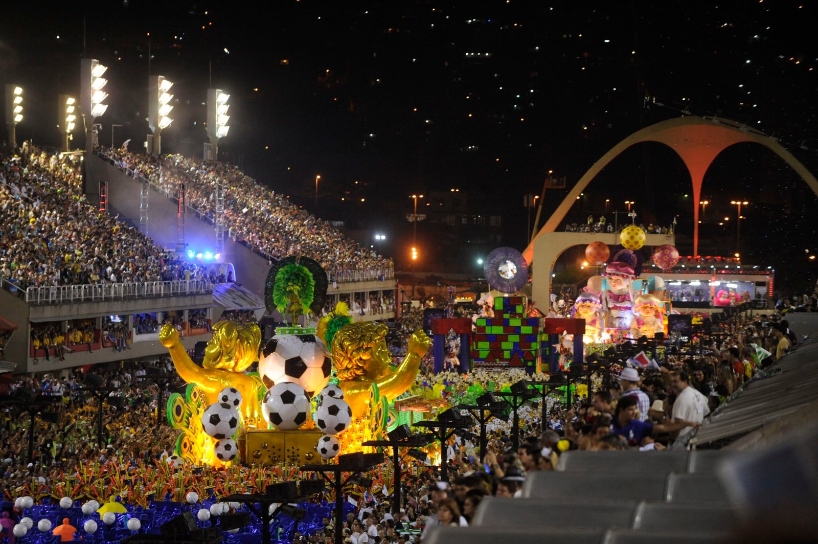The Sambadrome in Rio de Janeiro at night during Carnival, with a samba school float passing packed grandstands